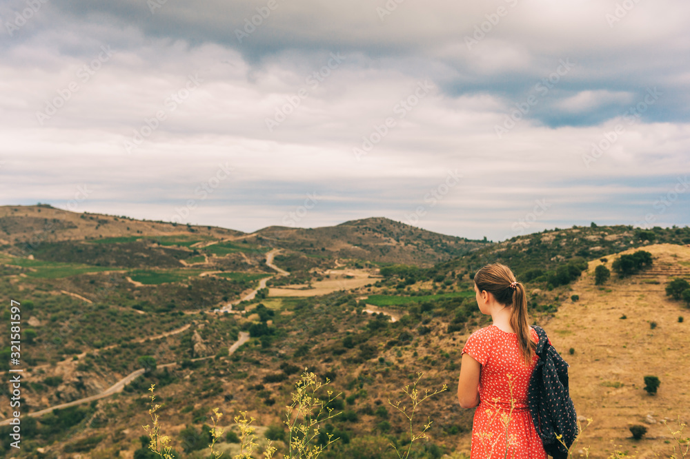 Naklejka premium Young girl tourist admiring landscape of Cap de Creus, National Park on the Costa Brava, Spain