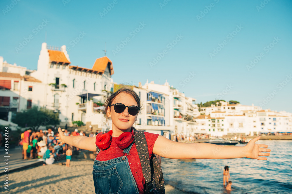 Φωτογραφία Close up portrait of happy teenage girl posing by the sea, wearing backpack and