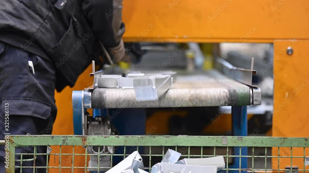 Operator working at Factory conveyor belt. Industrial manufacturing process. Metal stamped pieces production line. Metal manufacturing line. Manufacturing industry .