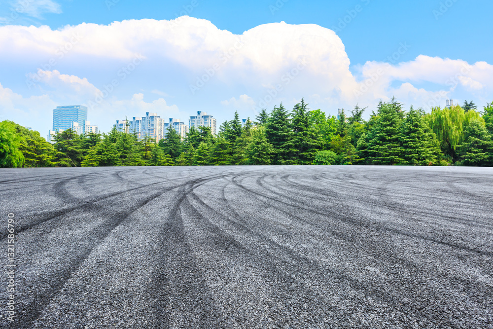Fototapeta premium Empty asphalt road and green forest under blue sky.