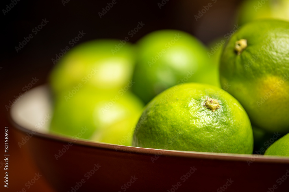 Fresh green limes in bowl 