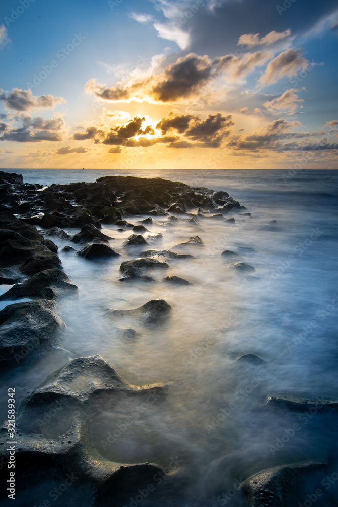 Surf flowing over rocks at sunrise on Singer Island