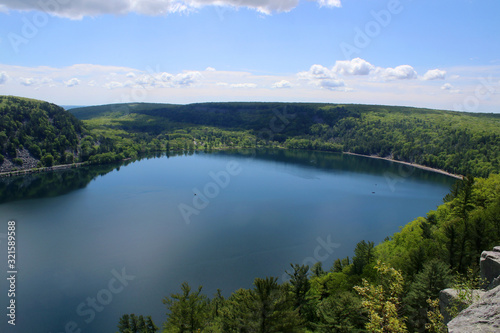 Fototapeta Naklejka Na Ścianę i Meble -  Beautiful Wisconsin late spring nature background. Areal view on the lake from West Bluff rocky ice age hiking trail. Devil's Lake State Park, Baraboo area, Wisconsin, Midwest USA.