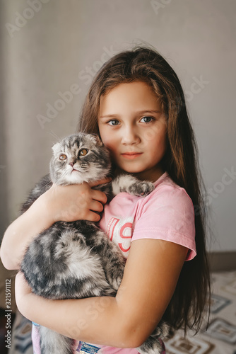 Beautiful causiasian girl hug scottish fold kitten at home. Pet animal concept.
