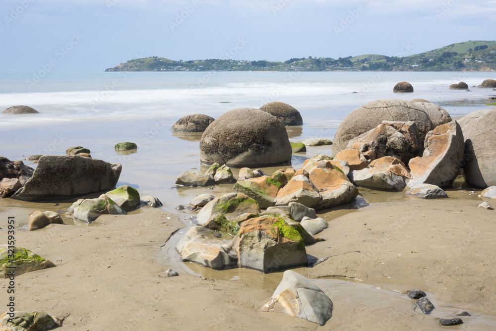 Moeraki boulders on Koekohe Beach on the Otago coast, New Zealand. One of the boulders in the foreground has disintegrated into pieces.