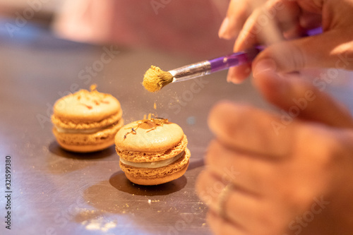 Bunte Macarons mit leckerer Frucht und Knusper Karamell Creme gefüllt Dekoriert mit essbaren Blüten und Glitzerpuder photo