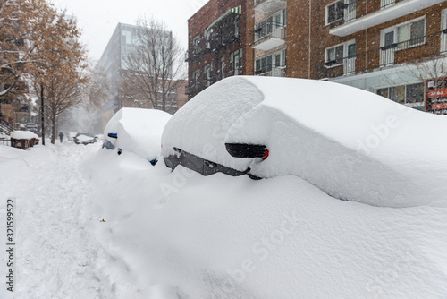 Принти на полотні Snow covered cars parked on side of road in a Montreal neighborhood with man wal