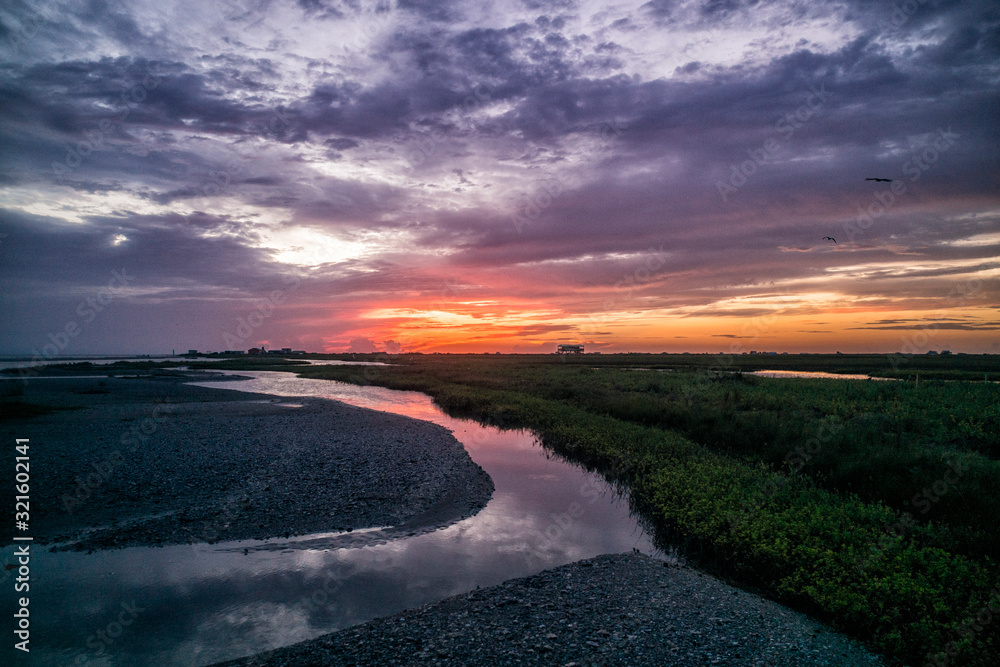 Fototapeta premium Dramatic beach sunrise with stream and cloudy skies in Matagorda Island Texas Gulf Coast