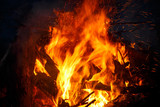 Colorful flame and sparks from a bonfire on a dark background