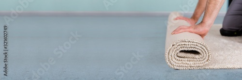 Fotografie Worker's Hands Rolling Carpet