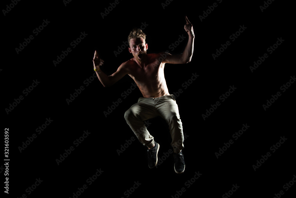 Silhouette of dancer in jump  with rising hands