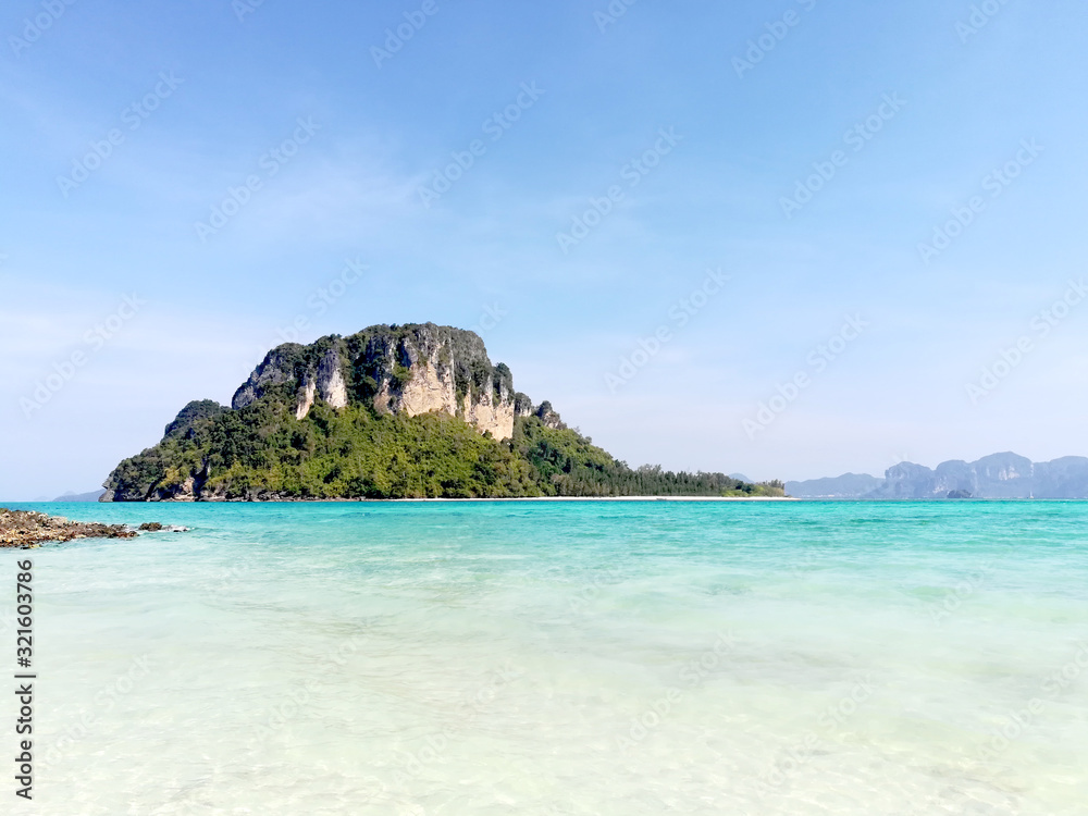 closeup and seascape view of island on Railay Bay on bright blue sky background.