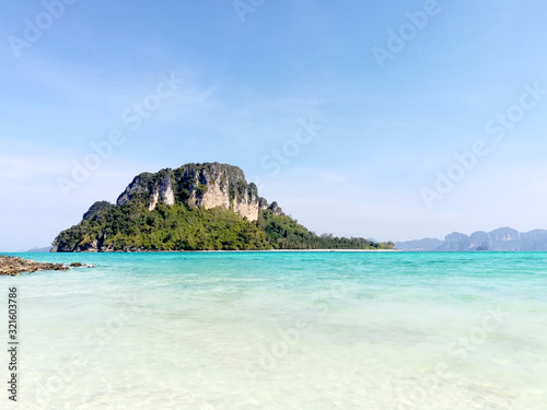 closeup and seascape view of island on Railay Bay on bright blue sky background.