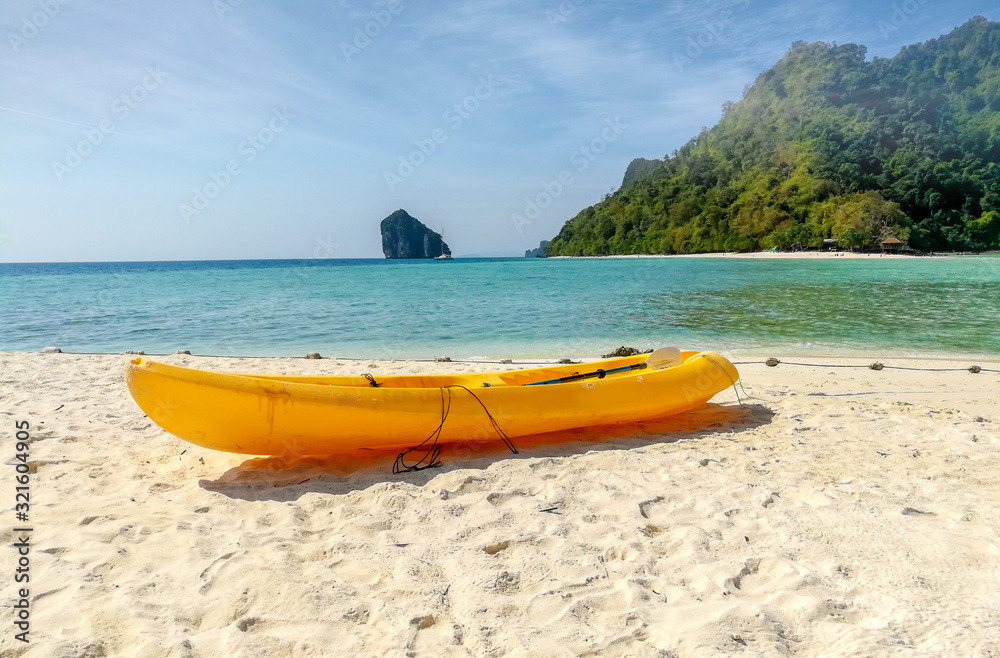 A bright yellow kayak park on the beach for tourists to rent at Ao nang, Thailand A bright yellow kayak park on the beach for tourists to rent at Ao nang, Thailand