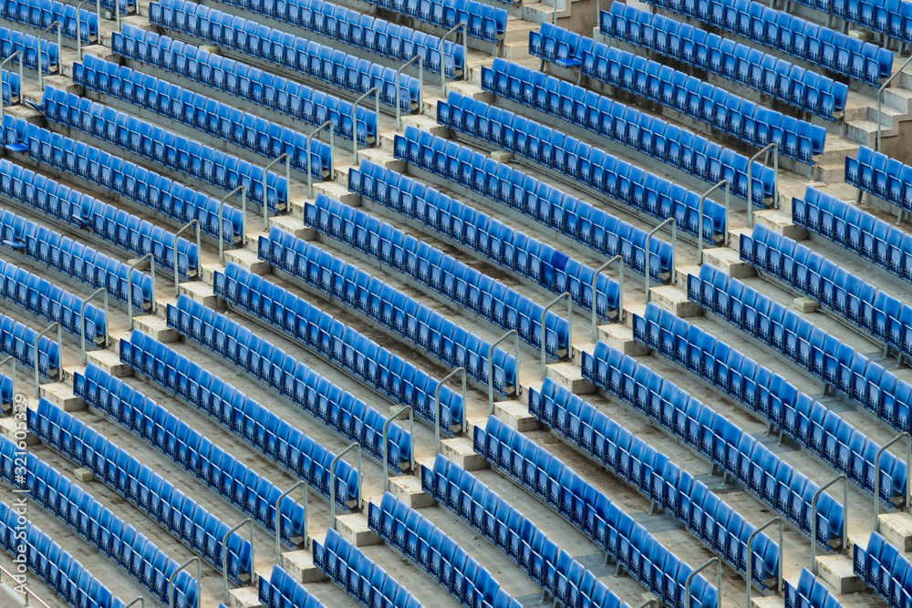 Rows of empty blue seats inside a football stadium