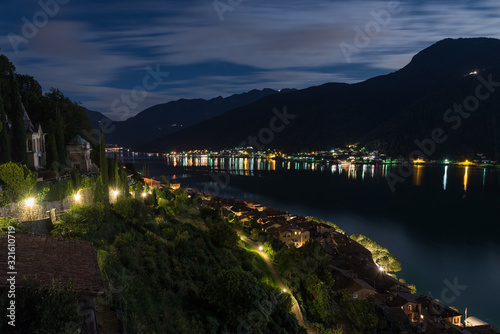 Lugano lake at night. Morcote village with the illuminated path that leads to the monumental cemetery (left) near the church of Santa Maria del Sasso. Switzerland, canton Ticino photo