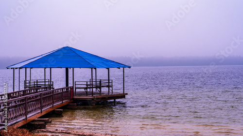 Winter holiday concept. Gazebo on the winter lake.