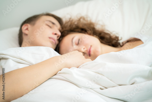 Happy caucasian couple sleeping relax on white bed