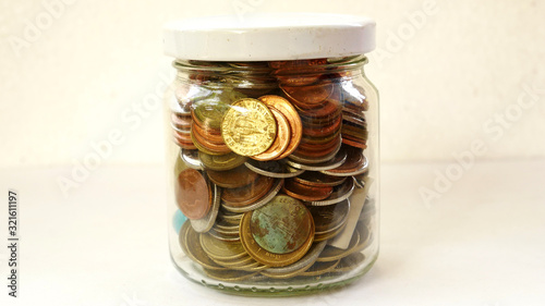 glass jar of gold coins isolated on white background
