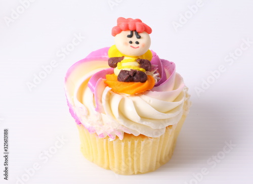 A colorful cupcake with doll on top   isolated