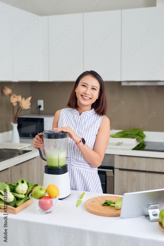 Healthy Asian woman enjoy making green vegetables detox cleanse and green fruit smoothie with blender in kitchen at home. dieting concept.healthy lifestyle Healthy Asian woman enjoy making green vegetables detox cleanse and green fruit smoothie with blender in kitchen at home. dieting concept.healthy lifestyle