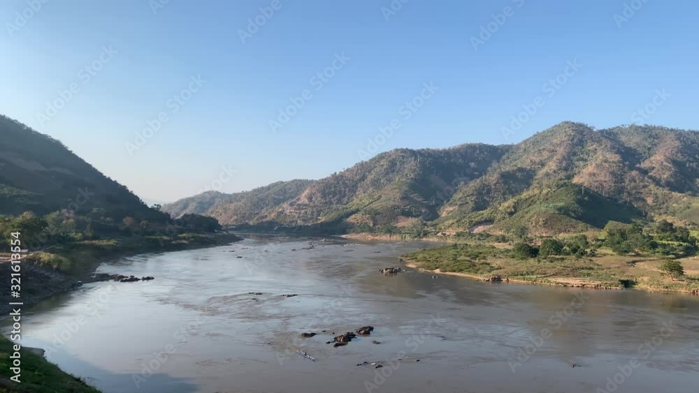 A kayaker enjoying an adventure in a river in Thailand by the mountains - aerial A kayaker enjoying an adventure in a river in Thailand by the mountains - aerial