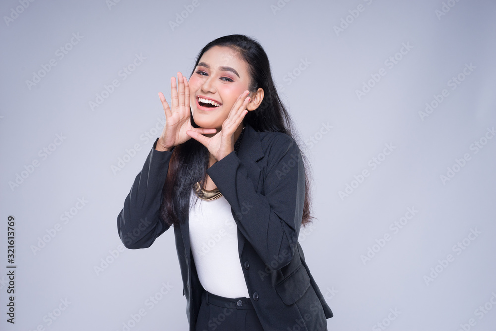 An attractive woman wearing business attire with gestures towards copyspace area isolated on grey. Good for manipulation works for technology, transportation, business or finance theme. An attractive woman wearing business attire with gestures towards copyspace area isolated on grey. Good for manipulation works for technology, transportation, business or finance theme.