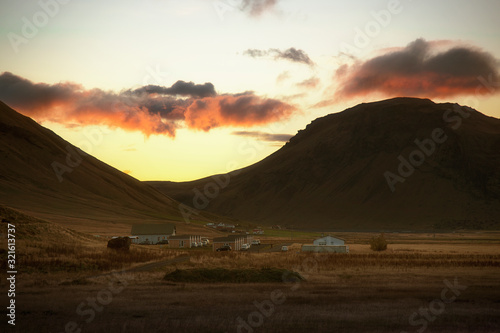 Beautiful golden sunset and big mountain surrounding arround small village in Iceland