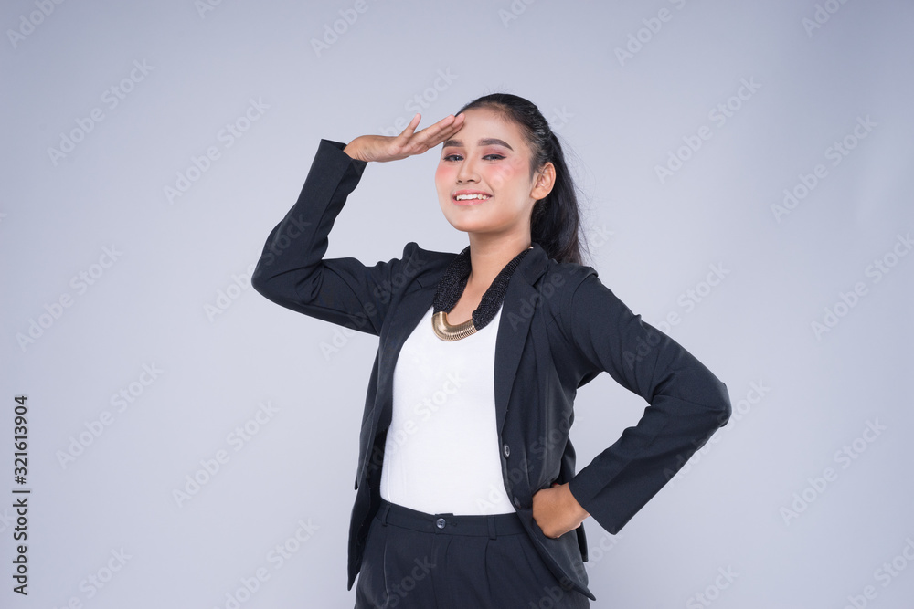 An attractive woman wearing business attire with gestures towards copyspace area isolated on grey. Good for manipulation works for technology, transportation, business or finance theme. An attractive woman wearing business attire with gestures towards copyspace area isolated on grey. Good for manipulation works for technology, transportation, business or finance theme.