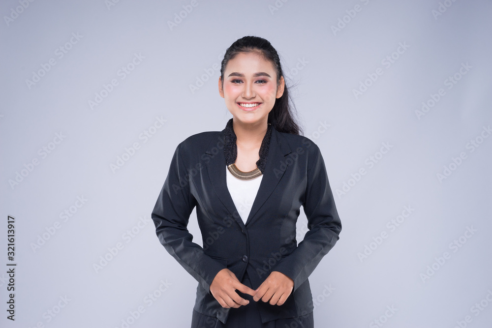 An attractive woman wearing business attire with gestures towards copyspace area isolated on grey. Good for manipulation works for technology, transportation, business or finance theme. An attractive woman wearing business attire with gestures towards copyspace area isolated on grey. Good for manipulation works for technology, transportation, business or finance theme.