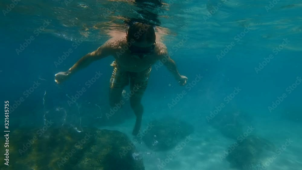 Man plays and makes bubble underwater. Freediver creates the bubble ring moving underwater Man plays and makes bubble underwater. Freediver creates the bubble ring moving underwater
