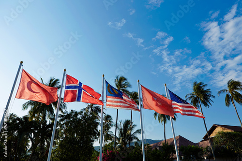 Wind blowing national flags, sky background 