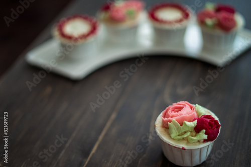 Beautiful cup cakes flowers from butter cream, in red and pink colour. Suitable for Birthday, Anniversary, Valentine Day and festive. selective focus