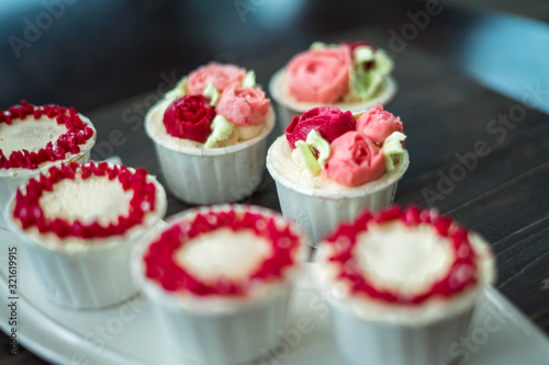 Beautiful cup cakes flowers from butter cream, in red and pink colour. Suitable for Birthday, Anniversary, Valentine Day and festive. selective focus