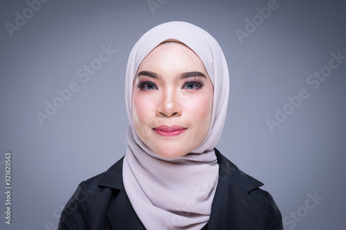Headshot portrait of an attractive Muslim woman wearing business attire and hijab with mixed poses isolated on grey background. For image cut-out for beauty, business or finance.