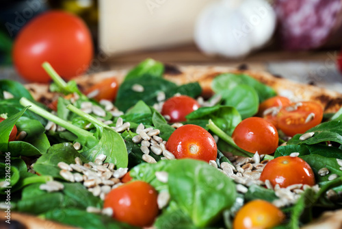 Italian style pizza, fresh arugula and cherry tomatoes prepared on wooden boards