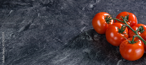 Frische, saftige rote Tomaten auf grauem Hintergrund (Arbeitsplatte) photo