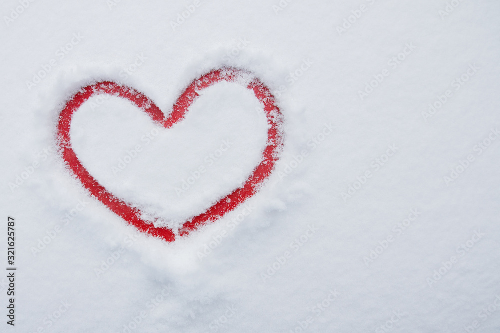 Red painted heart on white snow background
