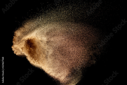 Dry river sand explosion isolated on black background. Abstract sand cloud.Brown colored sand splash.