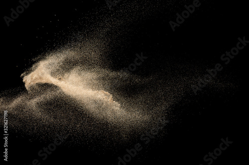 Brown dry river sand explosion isolated on black background. Abstract sand splash.