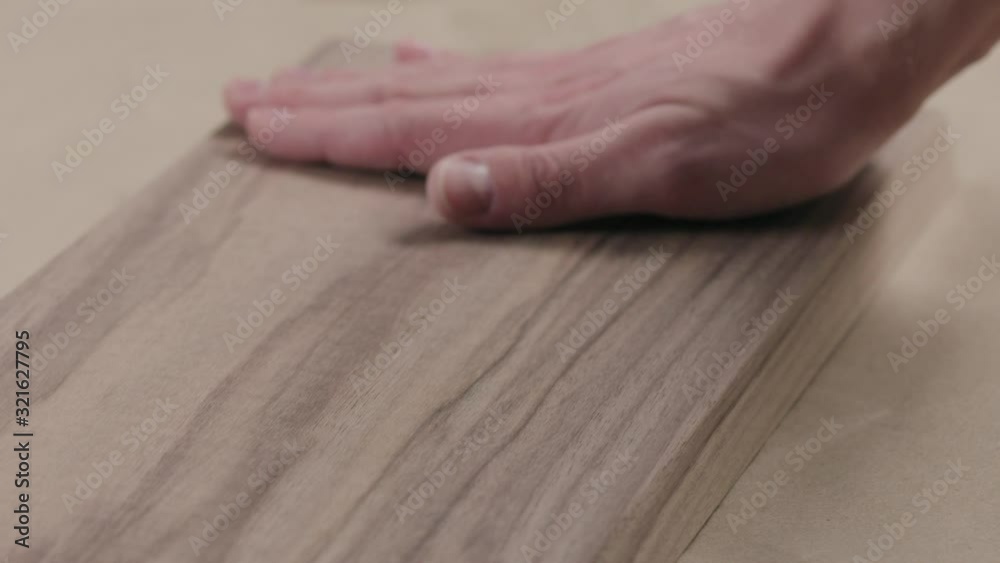 Slow motion man hand touches black walnut board Slow motion man hand touches black walnut board
