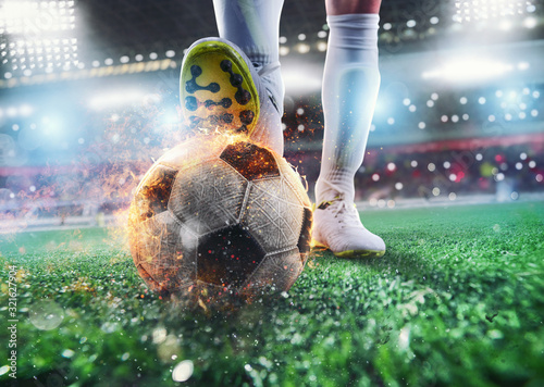 Naklejka Close up of a soccer striker ready to kicks the fiery ball at the stadium