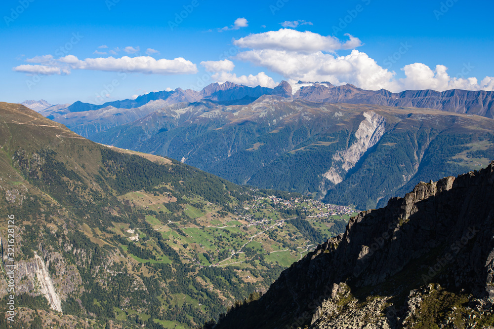 Stunning panorama view of the Swiss Alps mountain range of Valais (Wallis) from Fiescheralp and Bettmeralp near Great Aletsch Glacier on sunny day in summer with blue sky cloud background, Switzerland