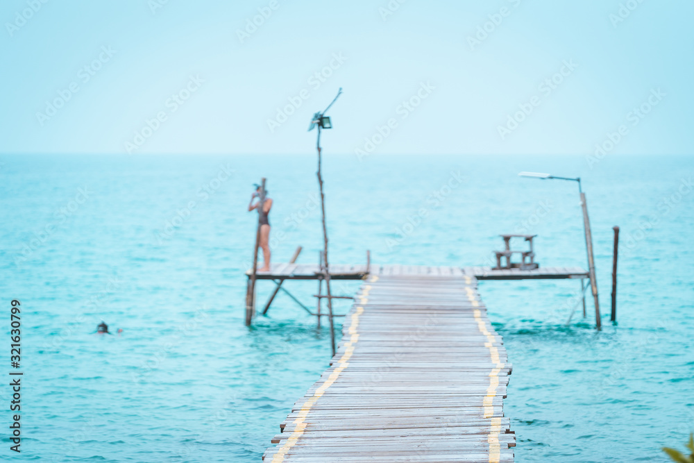 select focus walkway wood bridge in the sea with blur tourist jump in the sea in holiday relaxing concept select focus walkway wood bridge in the sea with blur tourist jump in the sea in holiday relaxing concept