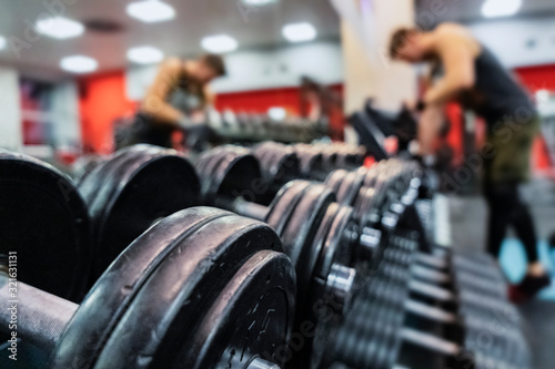 Close-up dumbbells on blurred background of a bodybuilder. Gym concept.