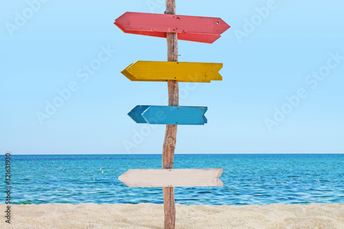 Signboard with arrows on the beach. 