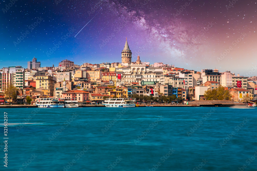 Obraz premium Wieża Galata w Stambule w Turcji. Widok na miasto Stambuł w Turcji z Bosfor, mewy i łodzie na jasne niebo i zachód słońca lub w nocy.