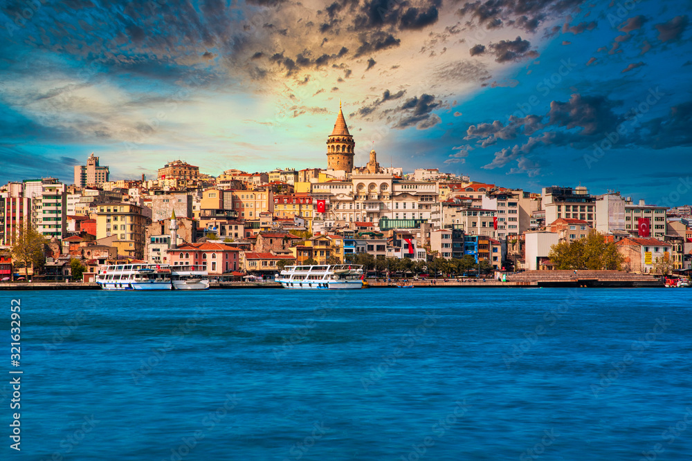 Naklejka premium Wieża Galata w Stambule w Turcji. Widok na miasto Stambuł w Turcji z Bosfor, mewy i łodzie na jasne niebo i zachód słońca lub w nocy.