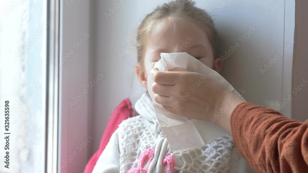 mother wipes snot with her daughter's handkerchief, child's cold mother wipes snot with her daughter's handkerchief, child's cold