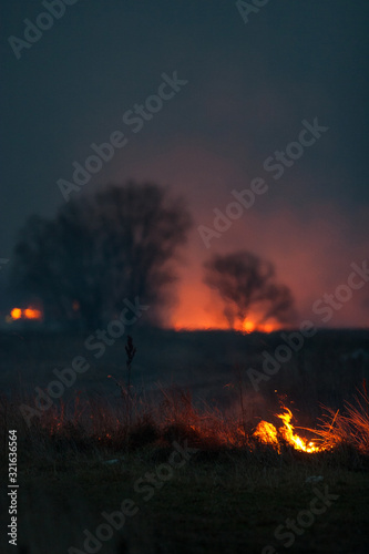 Dry grass burns at night. Pastures and meadows in the countryside. An environmental disaster involving irresponsible people. Luxurious mystical night landscapes shot on a 300mm lens. © Sodel Vladyslav